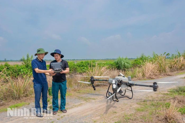 Lãnh đạo Trung tâm Dịch vụ sự nghiệp công phường Tây Hoa Lư hướng dẫn, hỗ trợ nông dân thực hiện quy trình phun thuốc BVTV bằng thiết bị bay không người lái đảm bảo an toàn, hiệu quả.