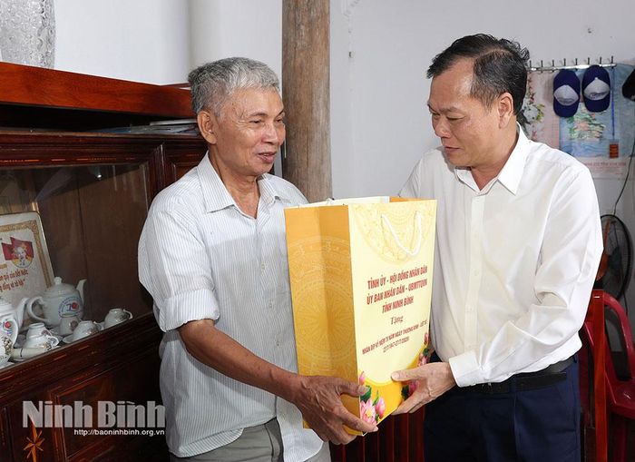 Đồng chí Lê Quốc Chỉnh, Phó Bí thư Tỉnh ủy, Chủ tịch HĐND tỉnh tặng quà gia đình bệnh binh Vũ Mạnh Hùng, trú tại thôn Nam Thành.