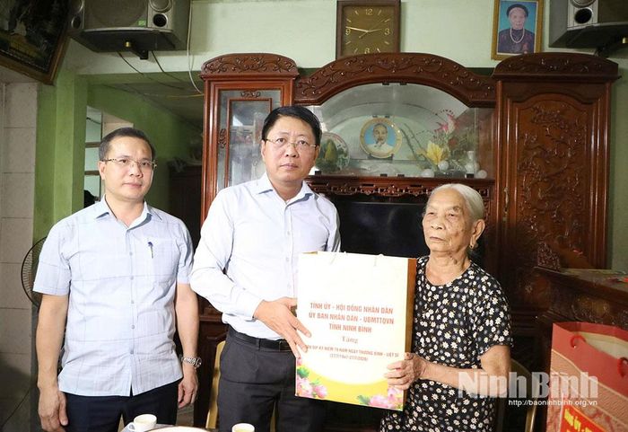 Đồng chí Trần Song Tùng, Ủy viên Ban Thường vụ Tỉnh ủy, Phó Chủ tịch Thường trực UBND tỉnh tặng quà bà Nguyễn Thị Diệp, là vợ liệt sĩ, ở thôn Bình Thành, xã Bình Sơn. Ảnh: Nguyễn Oanh