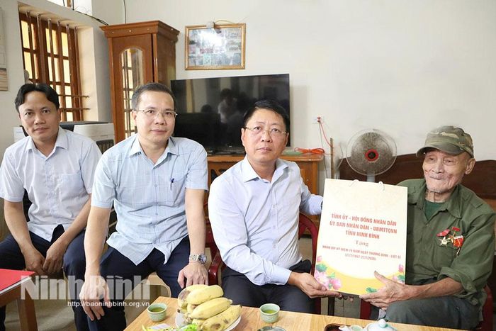Đồng chí Trần Song Tùng, Ủy viên Ban Thường vụ Tỉnh ủy, Phó Chủ tịch Thường trực UBND tỉnh tặng quà ông Nguyễn Văn Hòe, người hoạt động kháng chiến bị nhiễm chất độc hóa học và bị địch bắt tù đày, ở thôn Hòa Bình, xã Bình Sơn. Ảnh: Nguyễn Oanh