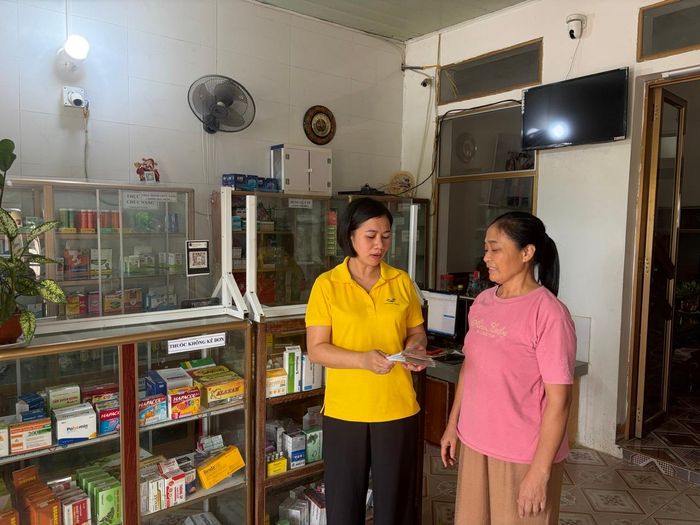 Nhân viên Bưu điện Tam Điệp tuyên truyền chính sách BHYT cho người dân.