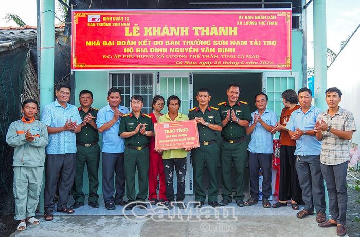 Thượng tá Hoàng Duy Cường, Phó Giám đốc Ban Trường Sơn Nam, Binh đoàn 12 (người trao bảng) cùng đại diện lãnh đạo Xã Hồ Thị Kỷ bàn giao nhà cho hộ anh Nguyễn Văn Định, Xã Lương Thế Trân. (Ảnh chụp ngày 26/6/2026)