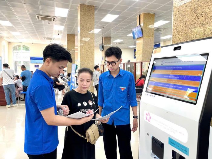 Tổ chuyển đổi số cộng đồng phường Từ Liêm hướng dẫn người dân thực hiện thủ tục hành chính trên nền tảng số. Ảnh: PV