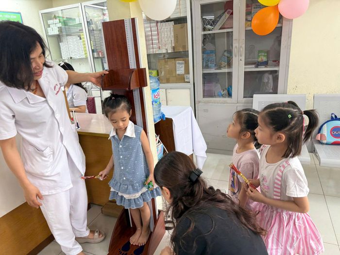 Kiểm tra cân nặng, đo chiều cao cho trẻ em tại chương trình. Ảnh: PV