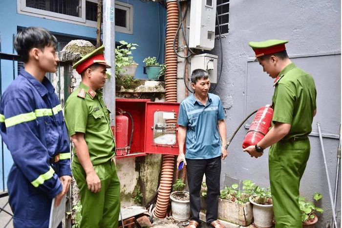 Hướng dẫn người dân sử dụng bình chữa cháy được trang bị tại các hộp họng nước chữa cháy trong ngõ sâu. Ảnh: PV