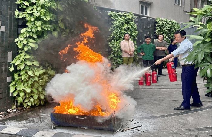 Cán bộ nhân viên thực hành sử dụng bình chữa cháy xách tay. Ảnh: PV