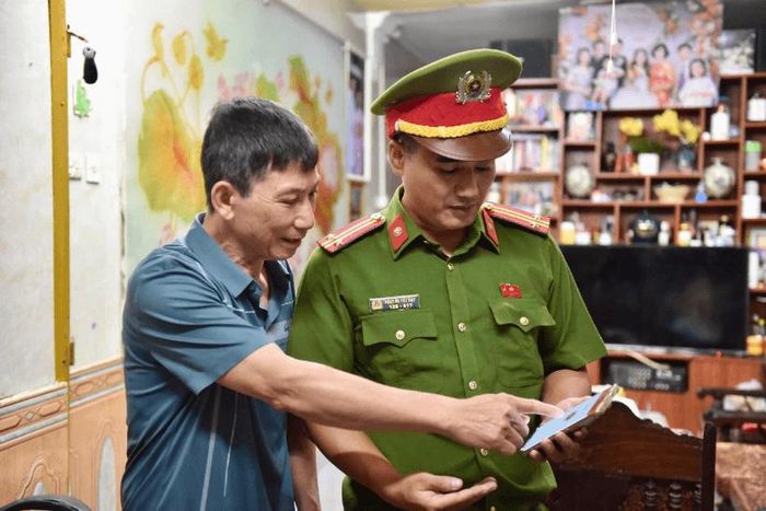 Công an phường Tây Hồ hướng dẫn người dân cài đặt ứng dụng “Báo cháy 114”. Ảnh: PV