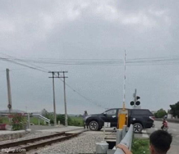 Hình ảnh nữ tài xế lái xe bán tải vượt đường sắt khi đèn đỏ