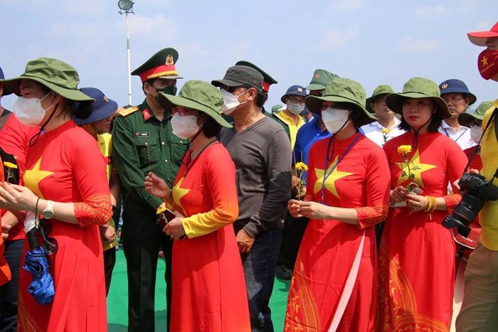 Mỗi người cầm một cánh hạc, hoặc một bông cúc xúc động thả xuống biển