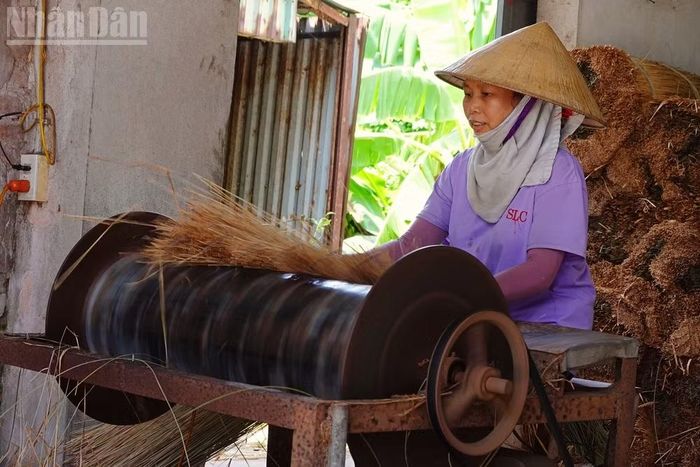 Bà Điều thoăn thoắt đánh bóng chiếu với sự hỗ trợ của máy móc. (Ảnh: Hà Thương)