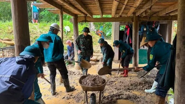 Lực lượng chức năng hỗ trợ người dân khắc phục hậu quả thiên tai.
