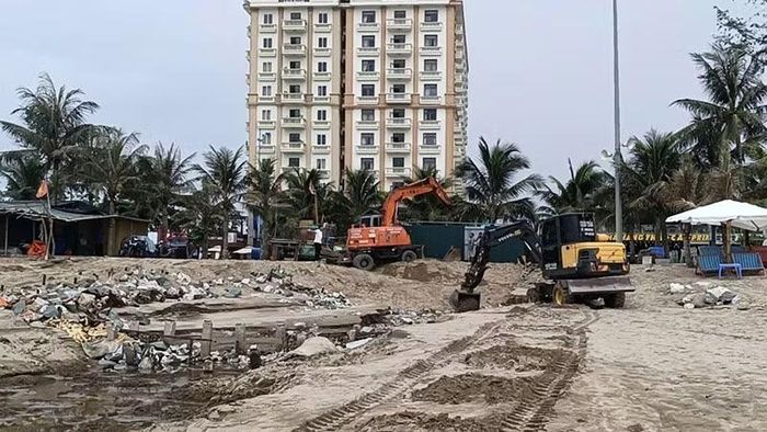 Phương tiện cơ giới cùng nhân lực xử lý điểm nước cống thoát ra biển.