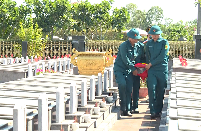 Cán bộ, chiến sĩ cẩn thận di chuyển hài cốt liệt sĩ sau khi bóc tách đất đá để đưa về khu vực chuyên môn. Ảnh: NGUYỄN KIM 