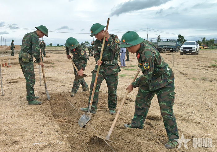 Cán bộ, chiến sĩ Đại đội Bộ binh 1 hỗ trợ người dân đào móng nhà.