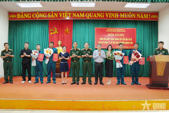 Các đại biểu tặng hoa chúc mừng 4 tiểu đội tự vệ mới được thành lập.