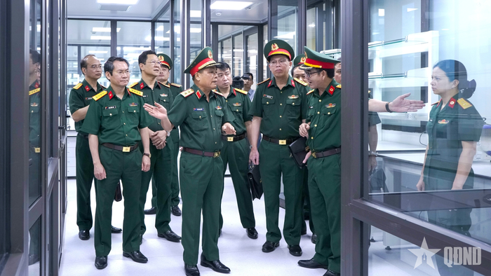 Đoàn công tác kiểm tra dây chuyền xét nghiệm của Viện Pháp y Quân đội. 