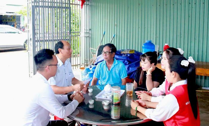 Ông Bùi Hữu Tâm (thứ 2 từ trái sang), Phó Bí thư Thường trực Đảng ủy xã, động viên gia đình anh Vi Hồng Quang. Ảnh: VHP