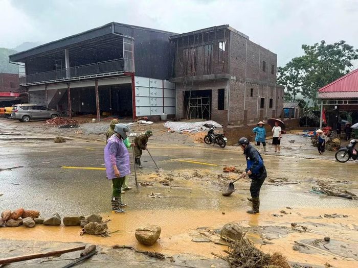 Lực lượng chức năng khẩn trương dọn dẹp đất đá, khơi thông tuyến đường, hỗ trợ các hộ dân bị ảnh hưởng.