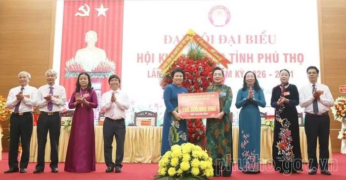 Bà Phạm Thị Hòe - Phó Chủ tịch Hội Khuyến học Việt Nam, Chủ tịch Hội đồng Quản lý Quỹ Khuyến học Việt Nam tặng hoa chúc mừng Đại hội và trao biểu trưng tặng 100 triệu đồng cho Hội Khuyến học tỉnh Phú Thọ (Ảnh: phutho.gov.vn).