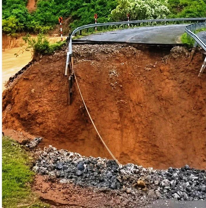 Lũ lớn cuốn trôi hàng chục mét mặt đường nhựa, tạo thành một hố sâu khoảng 10m. Ảnh: CACC