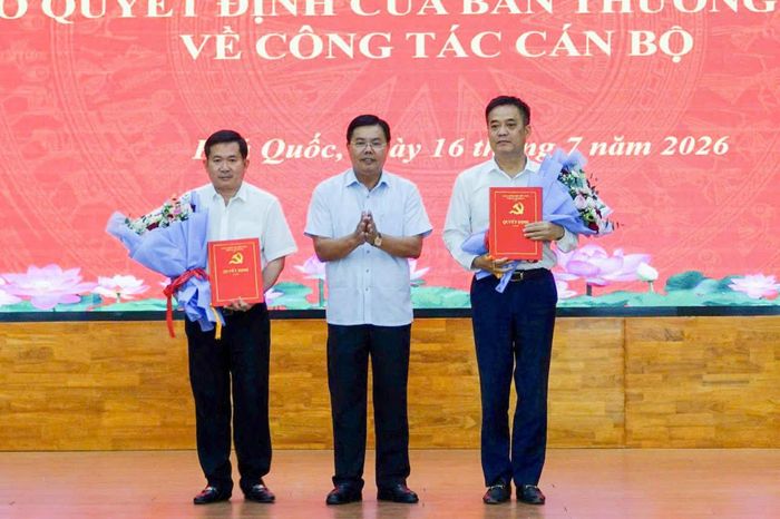 Bí thư Tỉnh ủy An Giang Nguyễn Tiến Hải (ở giữa) trao hoa và quyết định bổ nhiệm Phó Trưởng ban Tổ chức Tỉnh ủy An Giang Lê Quốc Anh (bìa phải) và Phó Bí thư Tỉnh ủy, Bí thư Đảng ủy đặc khu Phú Quốc Đinh Văn Nơi. Ảnh: Hoàng Dung
