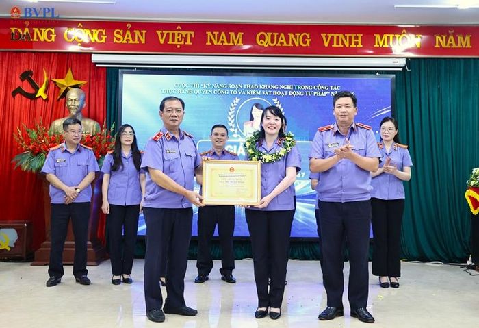  Đồng chí Nguyễn Xuân Hồng, Phó Viện trưởng VKSND tỉnh và đồng chí Nguyễn Văn Lượng, Phó Viện trưởng VKSND tỉnh trao Vòng nguyệt quế và Giấy chứng nhận đạt giải Nhất trong cuộc thi lĩnh vực Hành chính, Dân sự cho đồng chí Ngô Thị Lan Hương, Kiểm sát viên sơ cấp, Phó Viện trưởng VKSND khu vực 7. 