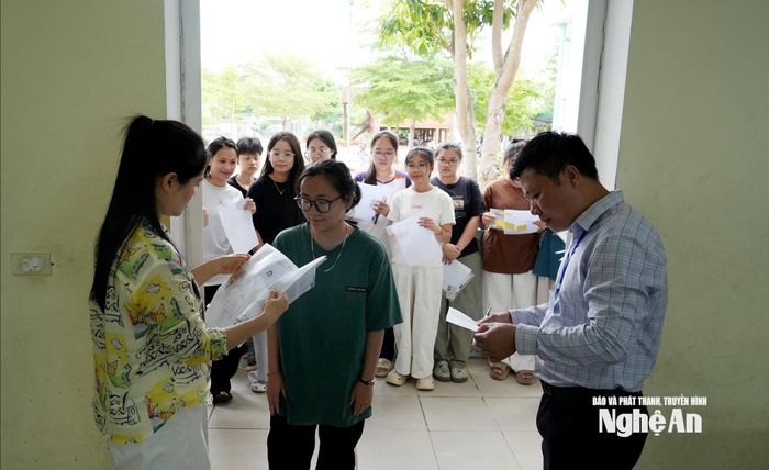 Các giám thị làm thủ tục gọi thí sinh vào phòng thi. Ảnh: Mỹ Hà