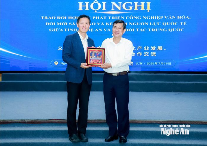 GS.TS Hướng Dũng - Viện trưởng Viện Nghiên cứu Công nghiệp văn hóa, Đại học Bắc Kinh tặng quà lưu niệm đến GS.TS Thái Văn Thành - Phó Chủ tịch UBND tỉnh Nghệ An. Ảnh: Thành Duy
