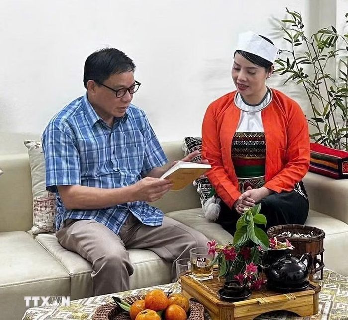 Chị Bùi Thị Linh (Bông Klăng) trao đổi với Chủ tịch Hội Liên hiệp Văn học Nghệ thuật Phú Thọ Lê Va về những giá trị văn hóa Mường truyền thống. (Ảnh: Vũ Hà/TTXVN)