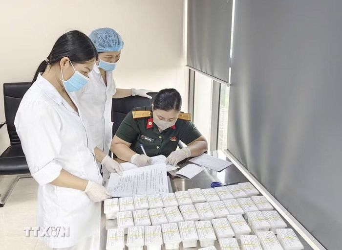 Các lực lượng chuyên môn đối chiếu, ký xác nhận biên bản bàn giao hồ sơ tiếp nhận mẫu hài cốt liệt sỹ. (Ảnh: TTXVN phát)