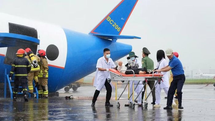 Đội Y tế khẩn nguy Cảng Hàng không quốc tế Nội Bài tiến hành cấp cứu cho 6 hành khách giả định bị thương tại buổi diễn tập. (Ảnh: PV/Vietnam+)