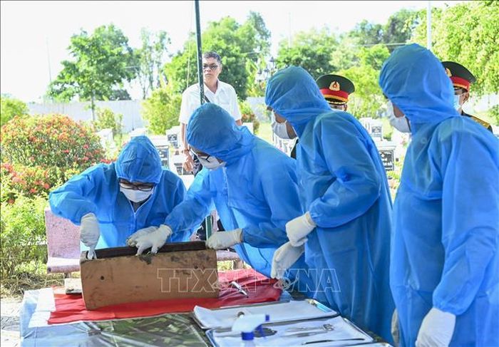 Công tác lấy mẫu xác định danh tính hài cốt liệt sĩ. Ảnh: TTXVN phát