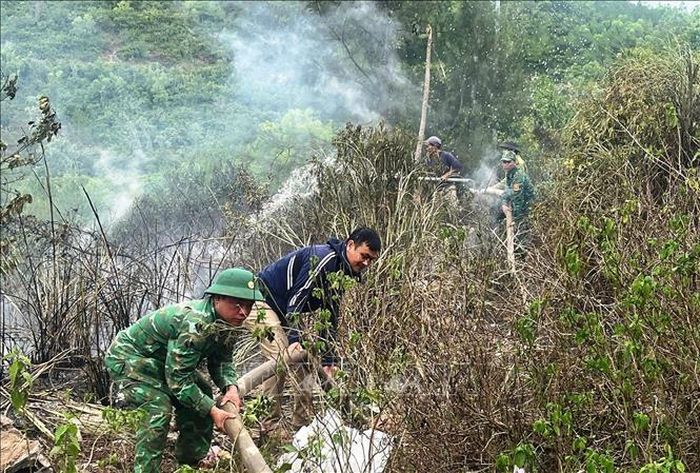 Các lực lượng tích cực khống chế đám cháy thực bì dưới chân đèo Lý Hòa, xã Đông Trạch, tỉnh Quảng Trị. Ảnh: TTXVN phát