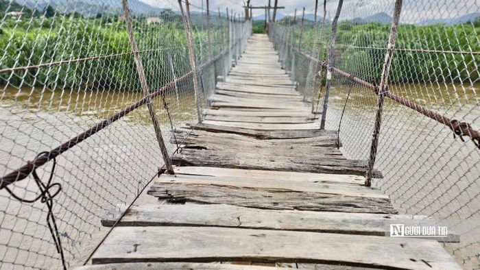 Cầu treo bắc qua sông Đăk Snghé, thôn Kon Vi Vàng, có nhiều đoạn mặt cầu mục nát, gãy ván, dây cáp hoen gỉ, mỗi lần có người qua lại đều rung lắc mạnh.