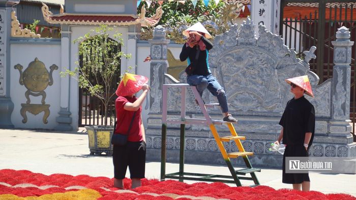 Người dân (giữa) chụp ảnh dịch vụ cho du khách tại làng tăm hương Quảng Phú Cầu.
