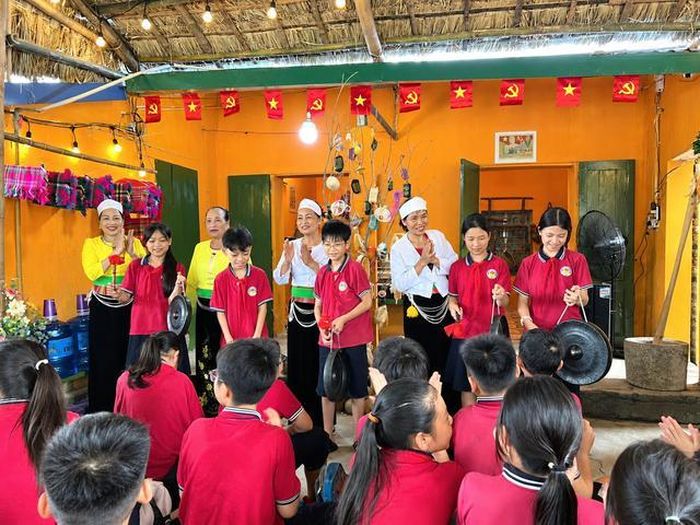Các em nhỏ thích thú trải nghiệm đánh chiêng dưới sự hướng dẫn của các nghệ nhân, qua đó hiểu hơn về giá trị của văn hóa truyền thống (Ảnh: Du lịch cộng đồng Mường Cốc).