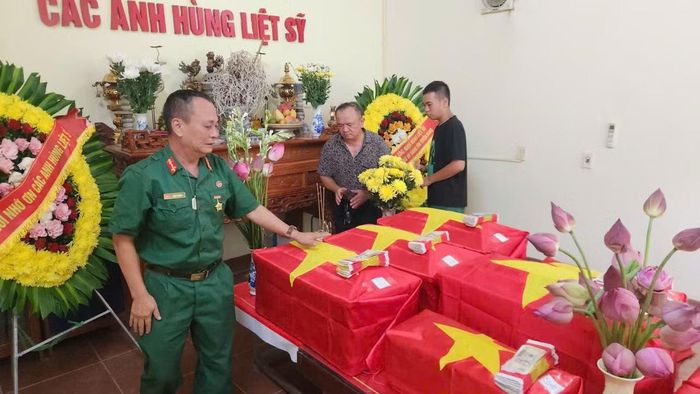 Hai bố con Trần Côn Sơn viếng hài cốt các liệt sĩ đang quàn tại Đội tìm kiếm quy tập. Ảnh: Thu Thủy.