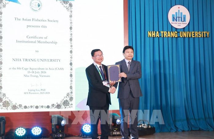 Giáo sư Liu Liping, Chủ tịch Hội Thủy sản châu Á trao Giấy chứng nhận thành viên cùng tổ chức hội thảo cho đại diện trường Đại học Nha Trang. Ảnh: Phan Sáu - TTXVN