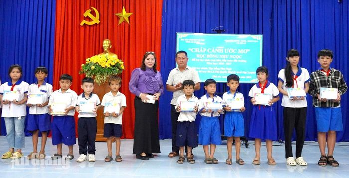 Đại diện các tổ chức, cá nhân trao học bổng cho học sinh nghèo xã Phú An. Ảnh: THANH THANH