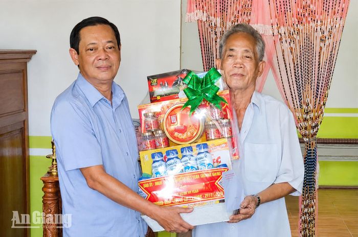 Phó Chủ tịch HĐND tỉnh An Giang Giang Văn Phục (bên trái) thăm, tặng quà ông Nguyễn Minh Thoàn là thương binh, ngụ xã Vĩnh Thuận.
