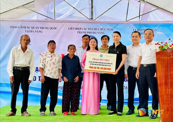 Đại diện Tổng lãnh sự quán Trung Quốc tại Đà Nẵng (thứ 3 từ phải sang) trao biểu trưng kinh phí hỗ trợ cải tạo nhà ở cho chính quyền xã Thăng Phú. Ảnh: ALĂNG NGƯỚC