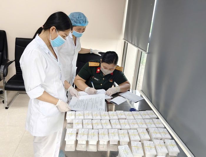 Lực lượng chuyên môn đối chiếu, ký xác nhận biên bản bàn giao hồ sơ tiếp nhận mẫu hài cốt liệt sĩ.