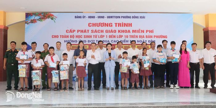 Ủy viên Trung ương Đảng, Phó Bí thư Thường trực Thành ủy, Chủ tịch HĐND thành phố Tôn Ngọc Hạnh và Ủy viên Ban Thường vụ Thành ủy, Phó Chủ tịch UBND thành phố Lê Trường Sơn hòa chung niềm vui với học sinh trong ngày ra mắt mô hình Thư viện sách giáo khoa dùng chung ở phường Đồng Xoài.