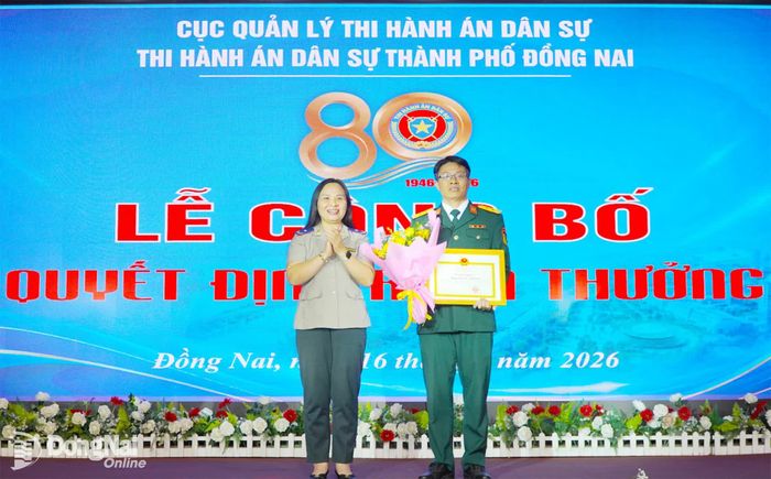 Phó Cục trưởng Cục Quản lý thi hành án dân sự (Bộ Tư pháp) Nguyễn Thị Hoàng Giang trao bằng khen của Bộ trưởng Bộ Tư pháp tặng đơn vị đạt thành tích xuất sắc trong công tác phối hợp thực hiện thi hành án dân sự. Ảnh: An Nhơn