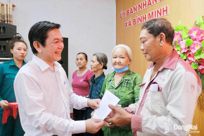 Bí thư Đảng ủy, Chủ tịch HĐND xã Bình Minh Nguyễn Kim Phước trao quà cho các gia đình chính sách, hộ nghèo trên địa bàn xã. Ảnh: Minh Hạnh