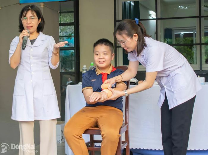 Học sinh được nhân viên y tế hướng dẫn cách xử lý vết thương. Ảnh: Công Nghĩa