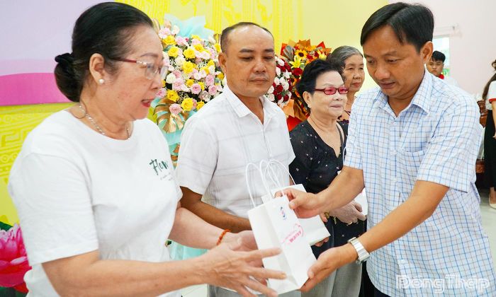 Đồng chí Võ Chí Hữu, Phó Chủ tịch Ủy ban Mặt trận Tổ quốc Việt Nam tỉnh Đồng Tháp trao tặng điện thoại thông minh cho người có công với cách mạng.