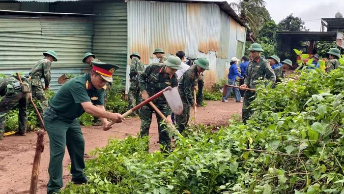 Các lực lượng tiến hành tổng vệ sinh môi trường tại làng Mook Đen. Ảnh: Văn Châu