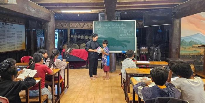  Giáo viên tình nguyện hướng dẫn học sinh giải bài tập Toán tại lớp học miễn phí ở làng Bồ. Ảnh: Ngọc Duy 