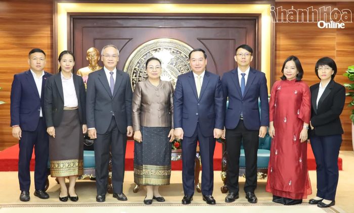 Đồng chí Hồ Xuân Trường và bà Khamphao Ernthavanh cùng các đại biểu chụp ảnh lưu niệm.